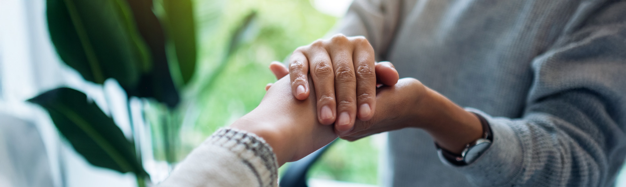 Women holding each other hands for comfort and sympathy