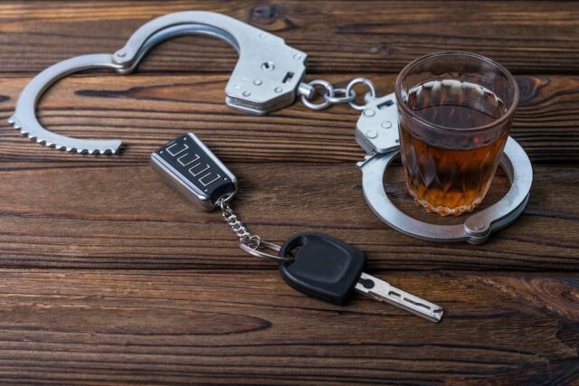 alcohol, car keys, and handcuffs on a table