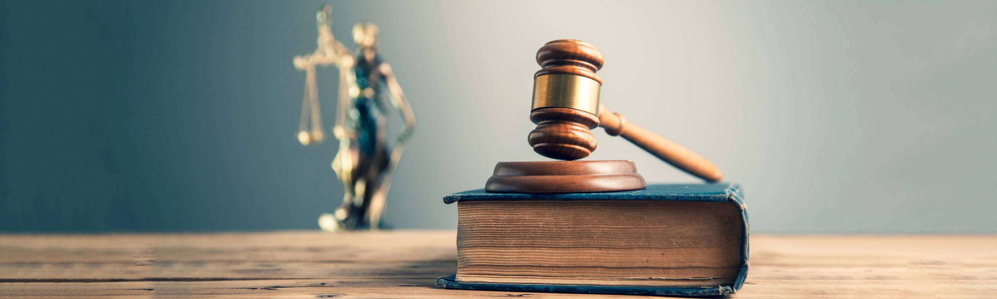 wooden judge on book with justice lady on desk