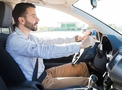 man gripping steering wheel