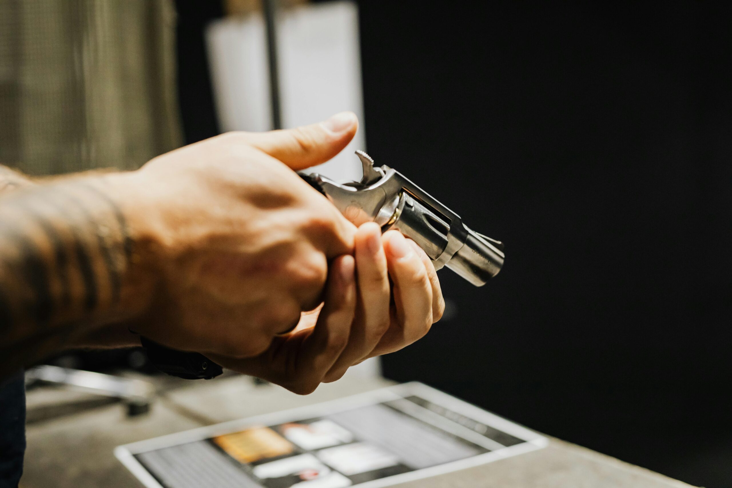 person's hands holding gun